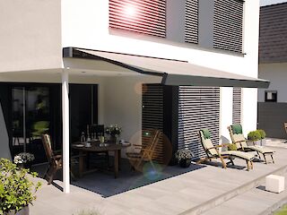 Ausgefahrene Markise über einer Terrasse mit modernen Gartenmöbeln