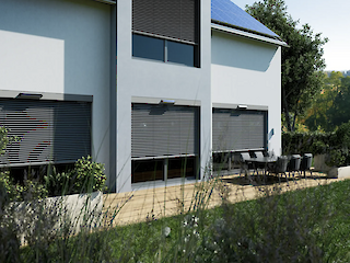 Moderner Terrassenbereich von außen mit teilweise heruntergefahrenen Rollläden
